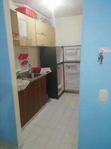 a small kitchen with a sink and a refrigerator at Apartamento vacacional en Flandes tolima in Flandes