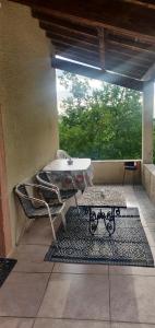 a patio with a table and chairs on a rug at Chez Fanny - Les Tuileries - Gîte 1-4 pers. avec jardin privatif - proche Cahors in Le Montat