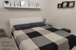 um quarto com uma cama com um cobertor preto e branco em Large house 3 floors City 'n sea em Vitinia