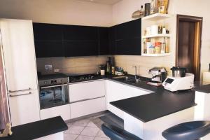 uma cozinha com armários brancos e bancadas pretas em Large house 3 floors City 'n sea em Vitinia