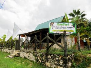 a sign in front of a building with flags at Hotel, boungalow y cabañas Xanfari in Colorado