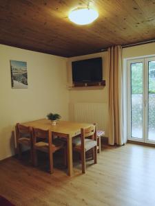 tavolo da pranzo con sedie e televisore a parete di Gemütliche Wohnung 10 Minuten vom See entfernt a Zell am See