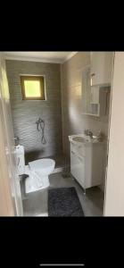 een badkamer met een wit toilet en een wastafel bij 1060 Meet Eat Hike & Tour in Plav