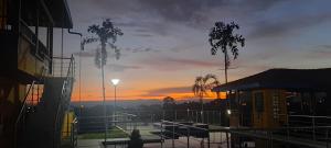 a sunset over a parking lot with trees and buildings at Ecohotel Guaduales Pereira in Pereira