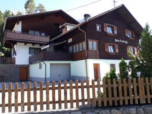 dom z drewnianym płotem przed nim w obiekcie Haus Tannegg w mieście Pettneu am Arlberg