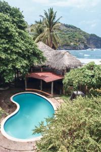 um resort com uma piscina e um telhado de palha em Esencia Nativa em El Zonte