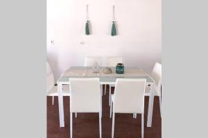 uma mesa de jantar branca com cadeiras brancas em Almarena, tu casa en Punta del Este em Manantiales