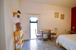 1 dormitorio con 1 cama, mesa y sillas en Hermosa Suite Privada en Casa Holística en Cuernavaca