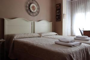 ein Schlafzimmer mit 2 Betten und einer Uhr an der Wand in der Unterkunft La Esquina de Castroviejo in Logroño