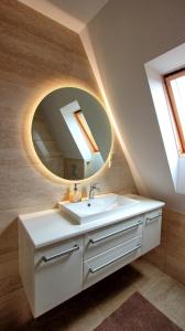 uma casa de banho com um lavatório e um espelho em DW Bianca em Darlowko