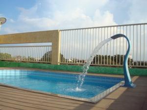 a swimming pool with a water fountain at Magnus Plaza Hotel in Macapá