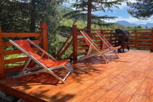 two chairs sitting on top of a wooden deck at Villa sul Lago di Campotosto in Campotosto