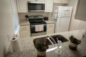 La cuisine est équipée d'un évier, d'une cuisinière et d'un réfrigérateur. dans l'établissement Spacious Home, Close to Attractions, Sleeps 4, à Orlando