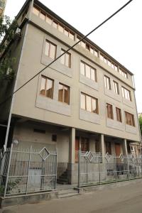 ein Gebäude mit einem Zaun davor in der Unterkunft Villa 29 in Yerevan
