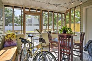 - une véranda avec une table et 2 vélos dans l'établissement Oak Island Cottage Minutes to Long Beach!, à Île au chêne