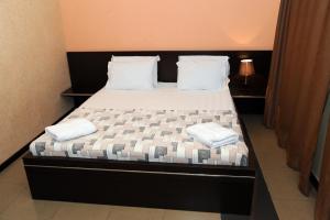 Schlafzimmer mit einem Bett mit weißer Bettwäsche und Kissen in der Unterkunft Villa 29 in Yerevan