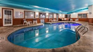einen Pool in einem Hotel mit Stühlen und Tischen in der Unterkunft Best Western Dodgeville Inn & Suites in Dodgeville