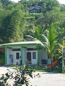 a small house with a palm tree in front of it at Suites Brejauva in Ubatuba