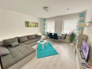 ein Wohnzimmer mit einer Couch und einem Tisch in der Unterkunft FeWo Rose - Mitten im Herz Goslar in Goslar