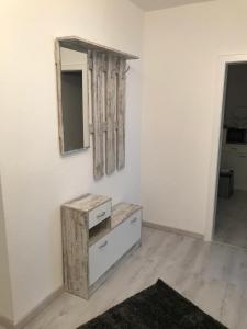 Zimmer mit einer Kommode und einem Spiegel an der Wand in der Unterkunft FeWo Rose - Mitten im Herz Goslar in Goslar + 7 Fotos