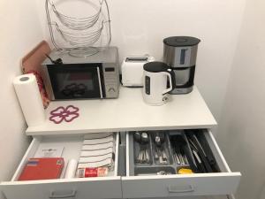 einen weißen Schrank mit Küchenutensilien in der Unterkunft FeWo Rose - Mitten im Herz Goslar in Goslar