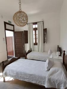1 dormitorio con 2 camas y lámpara de araña en Casa Kolla en Salta