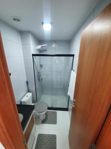 a bathroom with a shower and a toilet and a door at Flat Beira Mar - Piedade in Recife