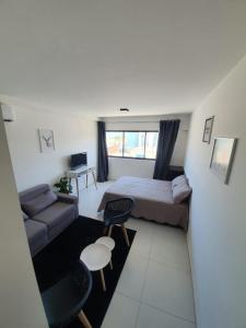 a small room with a bed and a couch and a table at Flat Beira Mar - Piedade in Recife