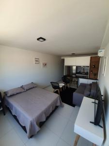 a bedroom with a bed and a couch and a table at Flat Beira Mar - Piedade in Recife