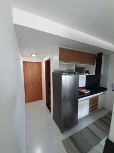 a kitchen with a stainless steel refrigerator in a room at Flat Beira Mar - Piedade in Recife