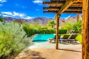 een achtertuin met een zwembad en een tafel en stoelen bij La Quinta Vacation Pool Home in La Quinta