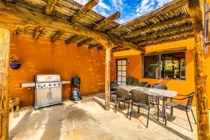 een patio met een fornuis, een tafel en stoelen bij La Quinta Vacation Pool Home in La Quinta