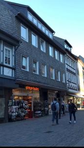 eine Gruppe von Menschen, die vor einem Gebäude spazieren gehen in der Unterkunft FeWo Rose - Mitten im Herz Goslar in Goslar
