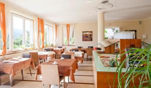 a restaurant with tables and chairs and windows at Hotel Residence Pernhof in Termeno