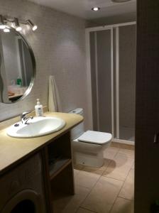 y baño con lavabo, aseo y espejo. en Apartamentos SOL Center Lloret, en Lloret de Mar