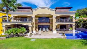 una casa grande con piscina frente a ella en Stunning beachfront Flamingo mansion with incomparable ocean setting, en Playa Flamingo