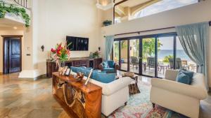 sala de estar con sofá, sillas y TV en Stunning beachfront Flamingo mansion with incomparable ocean setting, en Playa Flamingo