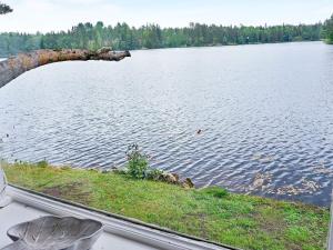 a view of a lake with a log sticking out of the water at 5 person holiday home in KERSBERGA in Åkersberga