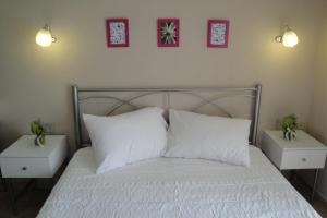 アスプロヴァルタにあるAmaryllis Studiosのベッド1台(白い枕2つ、ナイトスタンド付)