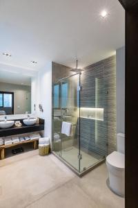 a bathroom with a glass shower and a toilet at Casa Naila Hotel Boutique in Oaxaca City