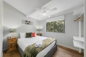 a bedroom with a white bed and white walls at Cottages On Mount View in Mount View