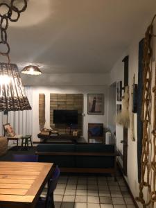 a living room with a couch and a television at 2 min do mar Ponta Verde in Maceió