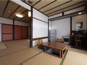 a room with a table and chairs and a kitchen at Shojuen in Minakami