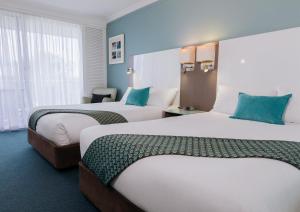 a hotel room with two beds and two lamps at Sea World Resort in Gold Coast