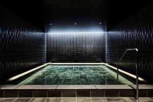 una piscina en una habitación oscura con luces en The Royal Park Canvas - Kyoto Nijo, en Kioto