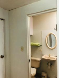 a bathroom with a toilet and a sink and a mirror at Parque & Mar lindo alojamiento en San Isidro in Lima