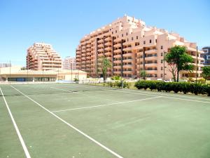 a tennis court in front of a building at Apartamentos Paraíso Sol da Rocha in Portimão