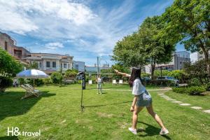 H& Taitung Feng Lin Resort Hotel في مدينة تايتونج: a woman playing a game in a park