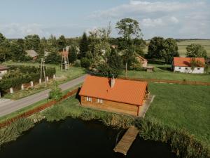 a house with an orange roof on a small island in the water at Zielone Zagrody - Cieplice in Adamówka