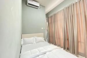 1 dormitorio con cama blanca y ventana en Pelangi Guest House Palembang RedPartner en Talang Kelapa